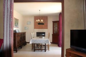 a dining room with a table and a brick wall at Gite Chez Jeanne in Pern