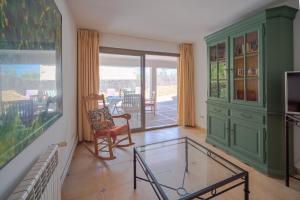 a living room with a glass coffee table and a balcony at Sa vinya in Colonia de Sant Pere