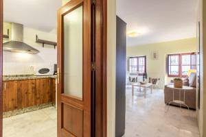 a kitchen and living room with a open door at Francos Cathedral in Seville +7 photos