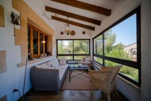 a living room with a couch and chairs and windows at Sa vinya in Colonia de Sant Pere