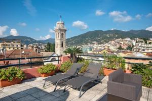 a group of chairs on a balcony with a clock tower at Appartamento Gabbiano in Rapallo