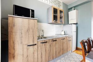 a kitchen with wooden cabinets and a sink and a microwave at 5 Terre - Lerici - Aless View in Lerici