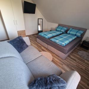 a living room with a bed and a couch at Fränkisch wohnen bei Mela in Litzendorf