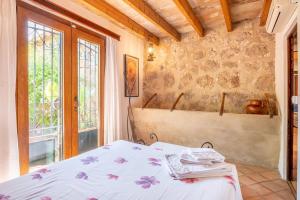a bedroom with a bed and a window at S Olivar Major in Fornalutx +18 photos