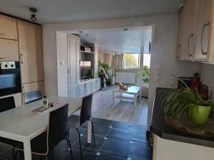 a kitchen and living room with a table and chairs at Le Coq De Champagne in Dormans