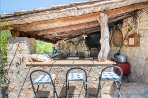 an outdoor kitchen with two chairs and a counter at S Olivar Major in Fornalutx