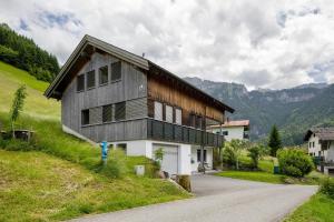 a house on the side of a hill with a road at Wiff's Studio in Mellau