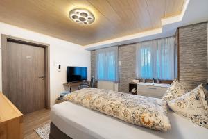 a bedroom with a bed with pillows and a television at Ferienwohnung Dina in Haslach im Kinzigtal