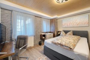 a bedroom with a bed and a desk and a television at Ferienwohnung Dina in Haslach im Kinzigtal