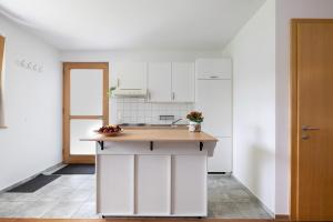a kitchen with white cabinets and a wooden counter top at Wiff's Studio in Mellau