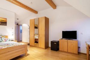 a bedroom with a bed and a flat screen tv at Pension Zum Talhof in Reichenau