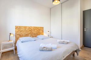 a bedroom with a large white bed with two pillows at Urania - Escale centre Concarneau in Concarneau