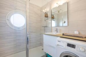 a bathroom with a washing machine and a sink at Urania - Escale centre Concarneau in Concarneau +14 photos