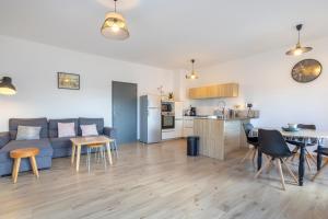 a living room and kitchen with a couch and a table at Urania - Escale centre Concarneau in Concarneau