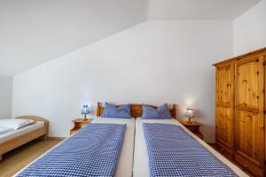 a bedroom with two beds with blue and white sheets at Fewo Brünnstein - Zimmer 55 in Oberaudorf