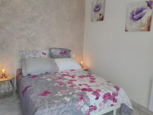 a bedroom with a bed with purple flowers on it at Gîte Le Campet in Millau +21 photos