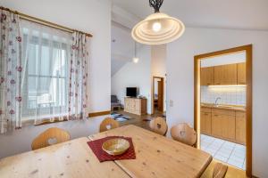 a kitchen and dining room with a wooden table and chairs at Fewo Brünnstein - Zimmer 55 in Oberaudorf