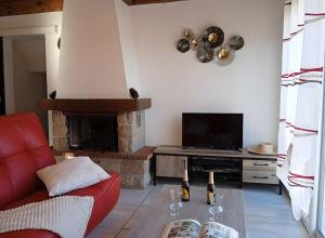 a living room with a red couch and a fireplace at Gîte Le Campet in Millau