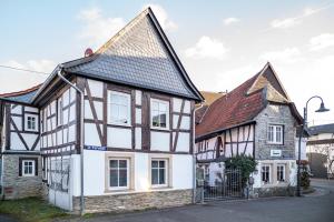 a white and black house with a brown roof at Wohnung 4 in Wallhausen