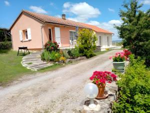 a house with flowers on a dirt road at Gîte Le Campet in Millau