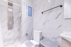 a white bathroom with a toilet and a shower at Corfu Haven in Ágios Rókkos +12 photos