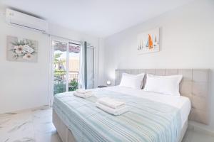 a white bedroom with a large bed with towels on it at Corfu Haven in Ágios Rókkos