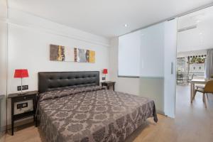 a bedroom with a bed and a table with a chair at Club Atlantis 159 in Adeje +15 photos