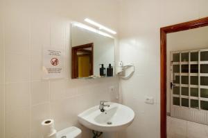 a white bathroom with a sink and a mirror at Apartamento Danoe 1 in Mogán +19 photos