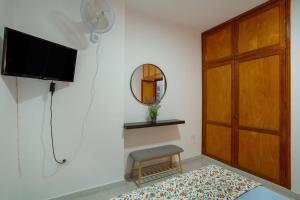 a living room with a tv and a wooden door at Apartamento Danoe 1 in Mogán