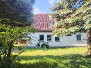 a white house with a red roof at Ferienwohnung Wilhelm in Züssow