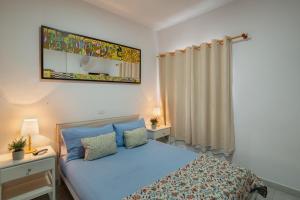 a bedroom with a blue bed and a mirror at Apartamento Danoe 1 in Mogán