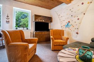 a living room with two chairs and a flat screen tv at Ferienwohnung Wilhelm in Züssow