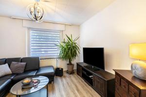 a living room with a couch and a flat screen tv at Lichtblick in Bottrop