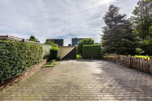 a brick driveway with a fence and a gate at Lichtblick in Bottrop