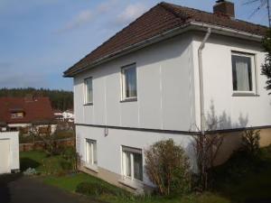 a white house with a brown roof at Ferienwohnung Oberamsel in Marburg an der Lahn