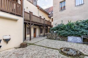 a courtyard with two buildings and a stone wall at Pension Ufert in Meißen