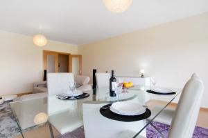 a dining room and living room with a glass table at A O - Apart Passarelle in Peniche