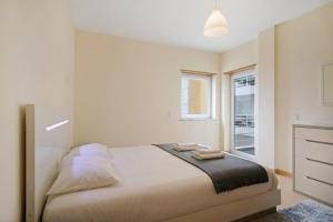 a bedroom with a bed with two towels on it at A O - Apart Passarelle in Peniche