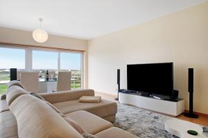 a living room with a couch and a flat screen tv at A O - Apart Passarelle in Peniche