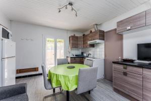 a small kitchen with a green table and chairs at Maison 3 étoiles, 300m de l’Océan in Biscarrosse