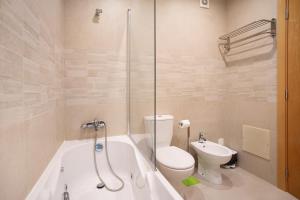 a bathroom with a tub and a toilet and a sink at A O - Apart Passarelle in Peniche +23 photos