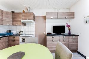 a kitchen with a table and chairs and a television at Maison 3 étoiles, 300m de l’Océan in Biscarrosse +15 photos