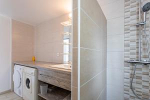 a bathroom with a sink and a washing machine at T3 Aramits Pyrénées Béarnaises in Aramits