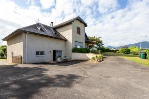 a white house with a black roof on a driveway at T3 Aramits Pyrénées Béarnaises in Aramits