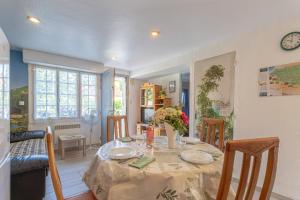 a dining room with a table with plates and flowers on it at T3 Aramits Pyrénées Béarnaises in Aramits +15 photos