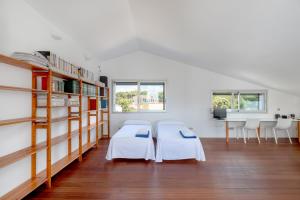 a room with two beds and bookshelves at Villa Xipell 9 in Cala Santandria +21 photos
