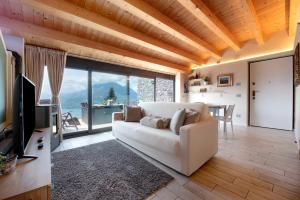 a living room with a white couch and a large window at Relax and Happiness private Jacuzzi in Perledo