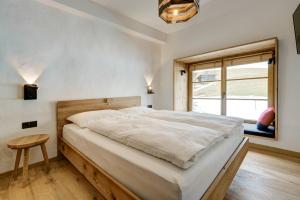 a bedroom with a large white bed and a window at Labe Biohof Oberzonn in Kastelruth
