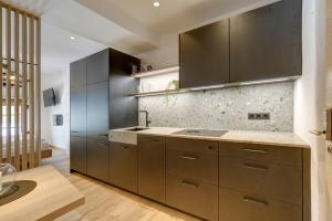 a kitchen with brown cabinets and marble counter tops at Labe Biohof Oberzonn in Kastelruth