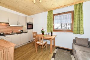 a kitchen and living room with a table and a couch at Joselehof App Arnika in Racines